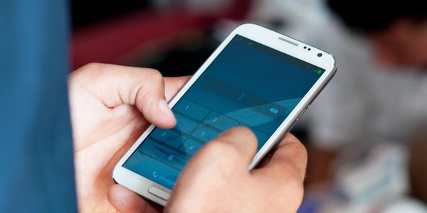 Hands holding smartphone — contact AllAmerica Investigations